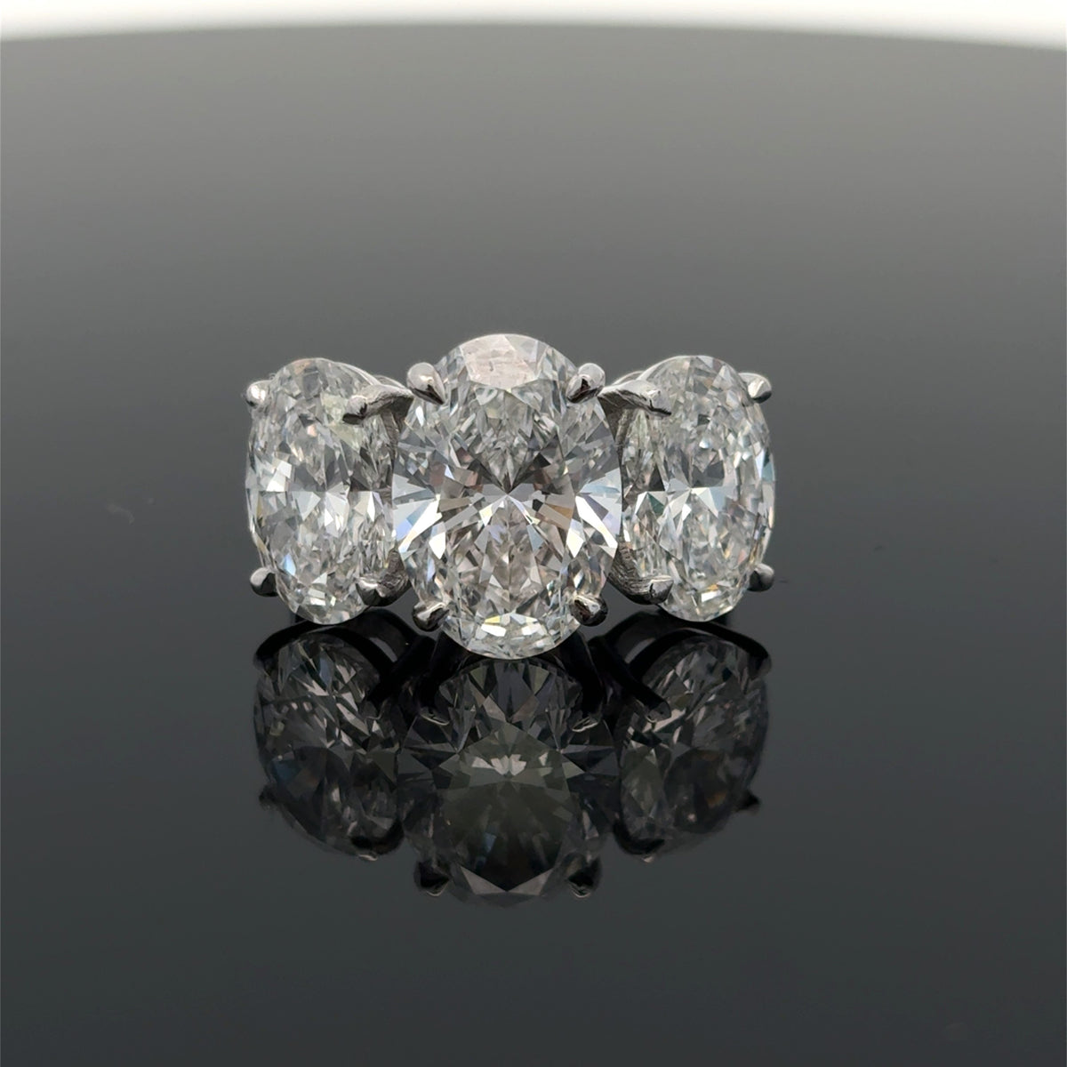 Platinum three stone engagement ring with an oval lab grown diamond, 7.81 carats total